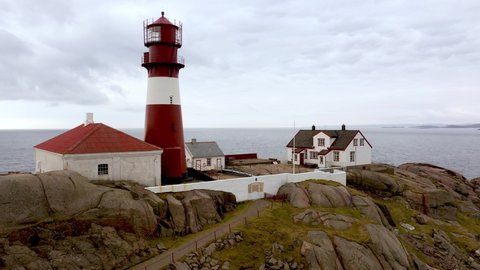 Beautiful aerial of Ryvingen lighthouse and lighthousekeepers home - Ascending aerial showing beautiful island with traditional lighthouse at Norway southern coastline with north sea in background