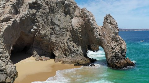 Drone shot of El Arco and Playa del Amor slowly revealing boats in the ocean in Cabo San Lucas Mexico