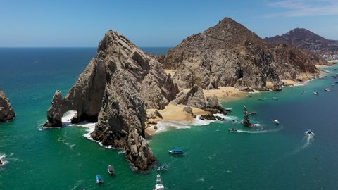 Drone shot of El Arco and Playa del Amor with boats in the ocean in Cabo San Lucas Mexico
