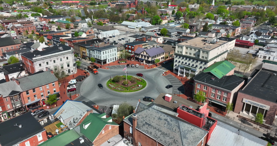 Downtown historic Gettysburg Pennsylvania. American flag and traffic in roundabout circle. Aerial view of Civil War History town in USA. Royalty-Free Stock Footage #1090090741