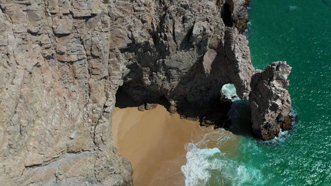 Cinematic drone shot of El Arco then revealing the sea cliffs and boats in Cabo San Lucas Mexico