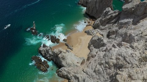 Cinematic drone shot of waves crashing on sea cliffs in Cabo San Lucas Mexico