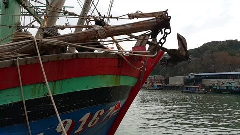 Cát Bà Island, Trân Châu, Cát Hải, Hai Phong, Vietnam December 13th 2016  A Vietnamese Fisherman drops good luck, votive, joss paper into the sea from a fishing boat