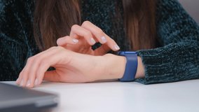 Girl using smartwatches. Young woman browsing notifications on modern smart wrist watches in closeup video