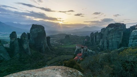 Time lapse of sunset to night transition with partly cloudy sky of the famous Eastern Orthodox monasteries, Meteora, Greece. UNESCO World Heritage