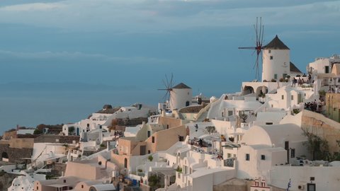 Beautiful view of famous Oia village with windmills in Santorini. Traditional whitewashed houses on the edge of a volcanic caldera on the island of Santorini in Greece.