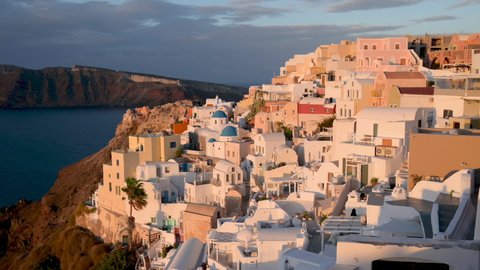 Beautiful panorama on the famous Oia village in Santorini at sunrise. Traditional whitewashed houses on the edge of a volcanic caldera on the island of Santorini in Greece.