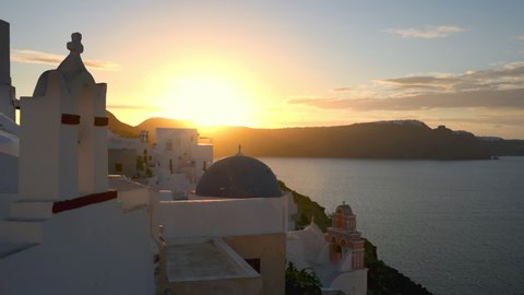 Beautiful panorama on the famous Oia village in Santorini at sunrise. Traditional whitewashed houses on the edge of a volcanic caldera on the island of Santorini in Greece.