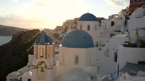 Beautiful panorama on the famous Oia village in Santorini at sunset. Traditional whitewashed houses on the edge of a volcanic caldera on the island of Santorini in Greece.
