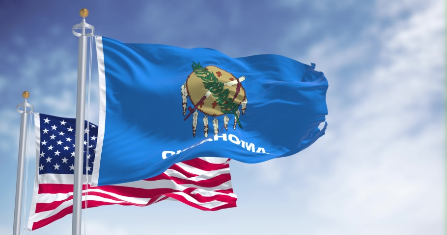 Seamless loop of the Oklahoma state flag waving along with the national flag of the United States of America. Oklahoma is a state in the South Central region of the United States