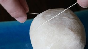 A close-up video of cutting fruit Daifuku with thread. Fresh kiwi inside.