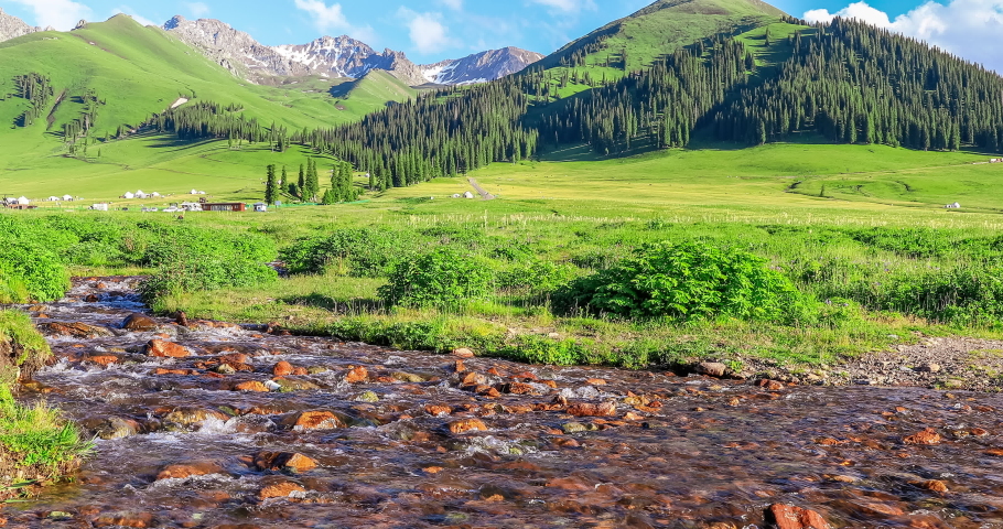 Streams and green mountains under the blue sky. Green grassland landscape in Xinjiang, China.