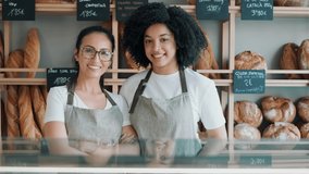 Video of two women owners selling fresh pastry and loaves un bread section and smiling at pastry shop. - Powered by Shutterstock - Get 15% off with code: PIKWIZARD15