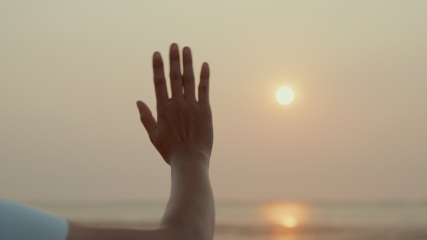 Woman waving hand say goodbye or parting with sunset alone on the seaside, Time to go farewell