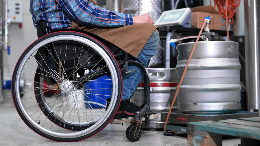 Man in wheel chair working in Brewery factory. High quality 4k footage