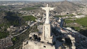 Aerial pov of symbolic sculpture of Christ of Monteagudo in Spain on top of ruined medieval castle