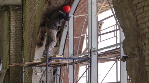 Construction worker using drill to install panoramic window timelapse. Construction equipment material with scaffolding and tools inside the floor of multi-level building