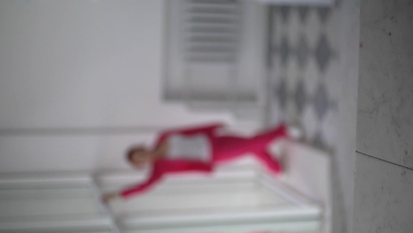 a girl in a pink suit in a rasofkus dances in the background.vertical video.object out of focus.