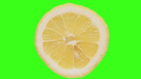 A close-up of a lemon cyclically rotates on a highlighted green background, chromakey. Fresh fruit. Refreshing, delicious, lemon fruit