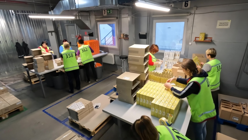Packing goods in boxes. Preparing goods for shipment. Logistics center. Women packing goods in boxes for shipping