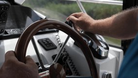 4k slow motion video with a man driving a boat during a cloudy day. Detail view with the gear and the steering wheel.