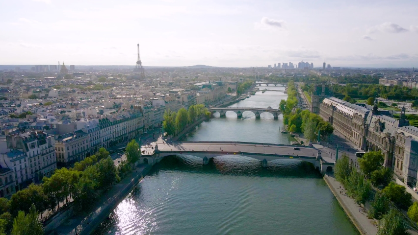 Paris aerial video with view of bridges, Seine river, Pont des Arts and Eiffel tower. Historic Parisian city center from above during warm summer. Famous holidays vacation destination