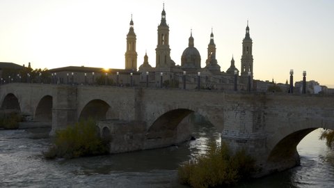 Basilica del Pilar Cathedral with stone bridge crossing Ebro River at sunset, Zaragoza, Aragon, Spain, Europe