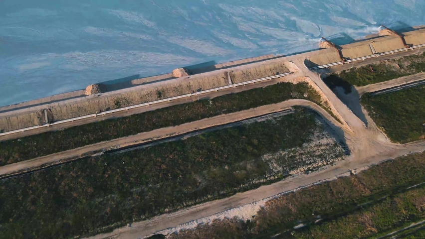 Nice scenic view on the lake with amazing water color located in a beautiful green valley close to Varna. Lake itself is a special basin for production of soda ash. Top view on the basin from drone.