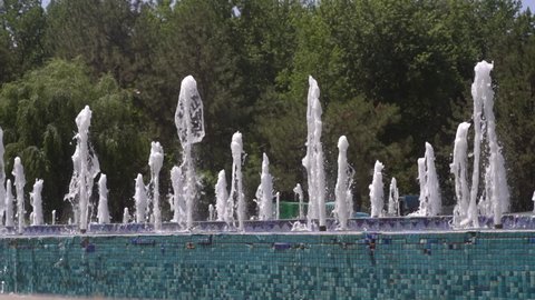 long rows of gushing fountains in the park, summer time