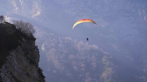 extreme paraglider flying in swiss alps, freedom concept. adventure sports video - paragliders flying over mountains on a beautiful sunny day. popular paragliding regions in Europe.