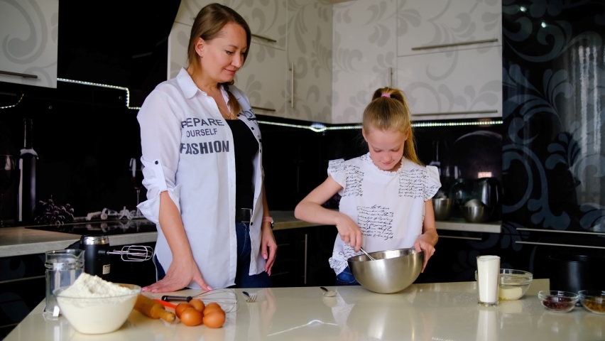 mom and daughter whisk the mass
