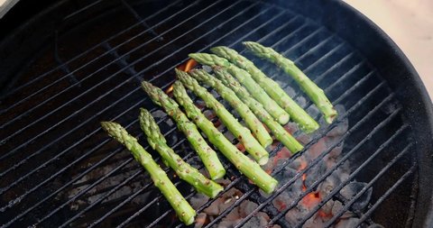 Asparagus on a charcoal grill zooming in