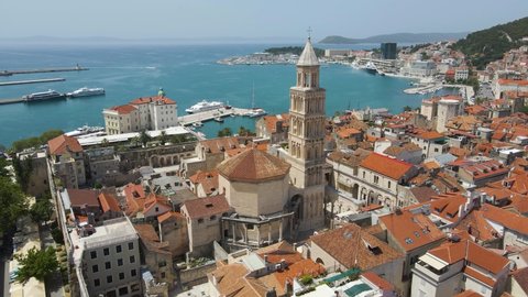 Aerial drone rotating shot over a popular tourist destination in Saint Domnius Cathedral and Diocletian's Palace, Split, Croatia at daytime. Sea beach visible in the background.