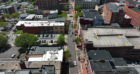 Urban city in USA on sunny day. Aerial tilt up reveal above street traffic.