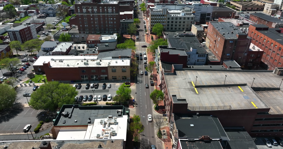 Urban city in USA on sunny day. Aerial tilt up reveal above street traffic.