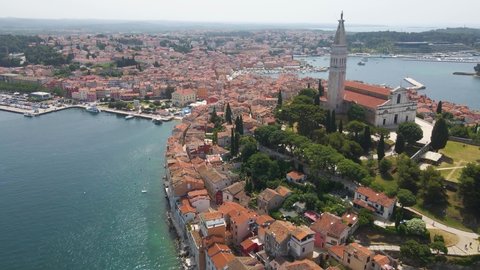 Aerial drone rotating shot of St. Euphemia church surrounded by medieval old town of Rovinj, Istria, Croatia on a bright sunny day.