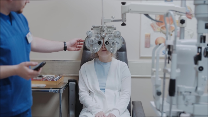 woman looking through optical Phoropter during eye exam, The expert is testing the vision test with diagnostic ophthalmology equipment, selective focus Royalty-Free Stock Footage #1090133525