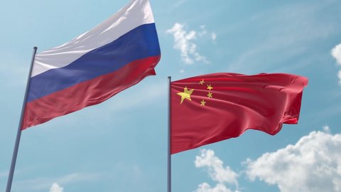 Flag of Russia and China on the flagpole flutters quickly with a strong wind in the blue sky