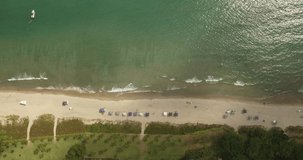 bird's eye view of beach with umbrellas and green sea