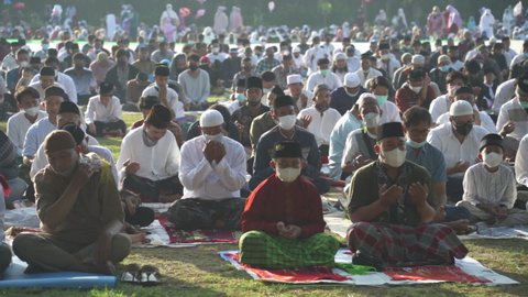 Bali, Indonesia - May 2 2022: Muslims Gather Celebrate Eid al-Fitr Salah Praying in a Park in Denpasar