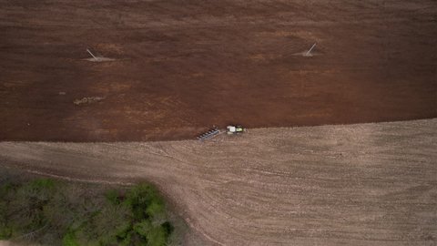 Tractor plowing field, drone view. Cultivated land and soil tillage. Tractor with disc cultivator on cultivating. Agricultural tractor on field cultivation. Tractor disk harrow on plowing field. Plow.