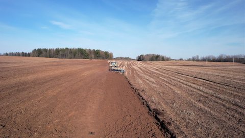 Tractor plowing field, drone view. Cultivated land and soil tillage. Tractor with disc cultivator on cultivating. Agricultural tractor on field cultivation. Tractor disk harrow on plowing field. Plow.