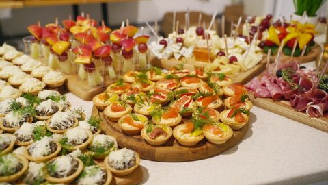 Catering service on banquet table with canape snacks in restaurant or hotel. Decorated food set on birthday, wedding celebration or business conference event venue.