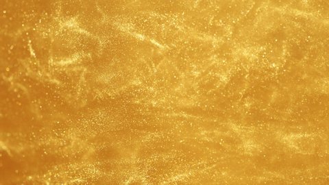Super slow motion of glittering golden particles in water. Abstract luxury style background. Filmed on high speed cinema camera, 1000 fps.