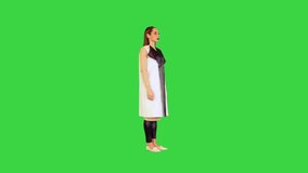 Robotic girl stands operating virtual monitors on a Green Screen, Chroma Key.