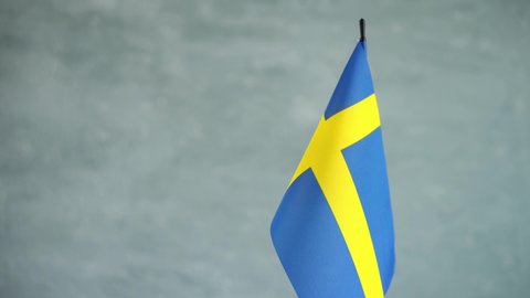 State flag of Kingdom of Sweden waving on light background. Swedish flag and place for text