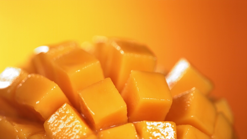 Slow Motion Shot of Mango Juice Splashing through Mango Cube Slices Royalty-Free Stock Footage #1090152375