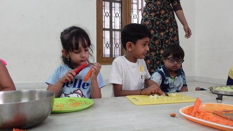Bangalore, India 9th May 2022: Indian kids enjoying and working in a Fun Summer camp. Teaching cooking and skills in a fun-based camp. Kids and children learning life skills.