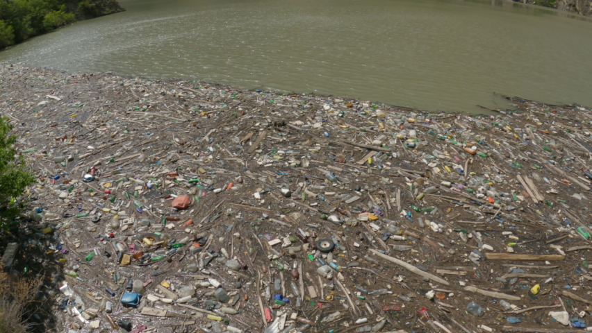 Garbage floats in water. Plastic bottles, boards on water surface. Ecology | Shutterstock HD Video #1090154041