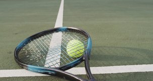 Video of tennis racket and ball lying on tennis court. active lifestyle, sport, hobby and tennis training concept.